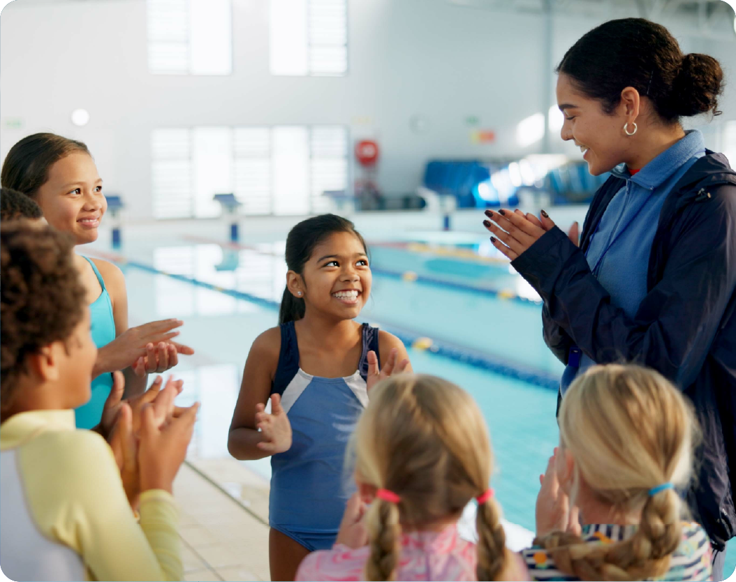 Swimming instructor with children poolside
